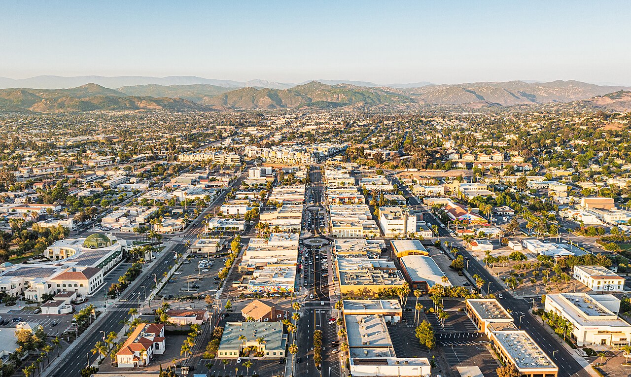 Aerial view looking northeast along Grand Avenue through downtown Escondido toward surrounding hills.