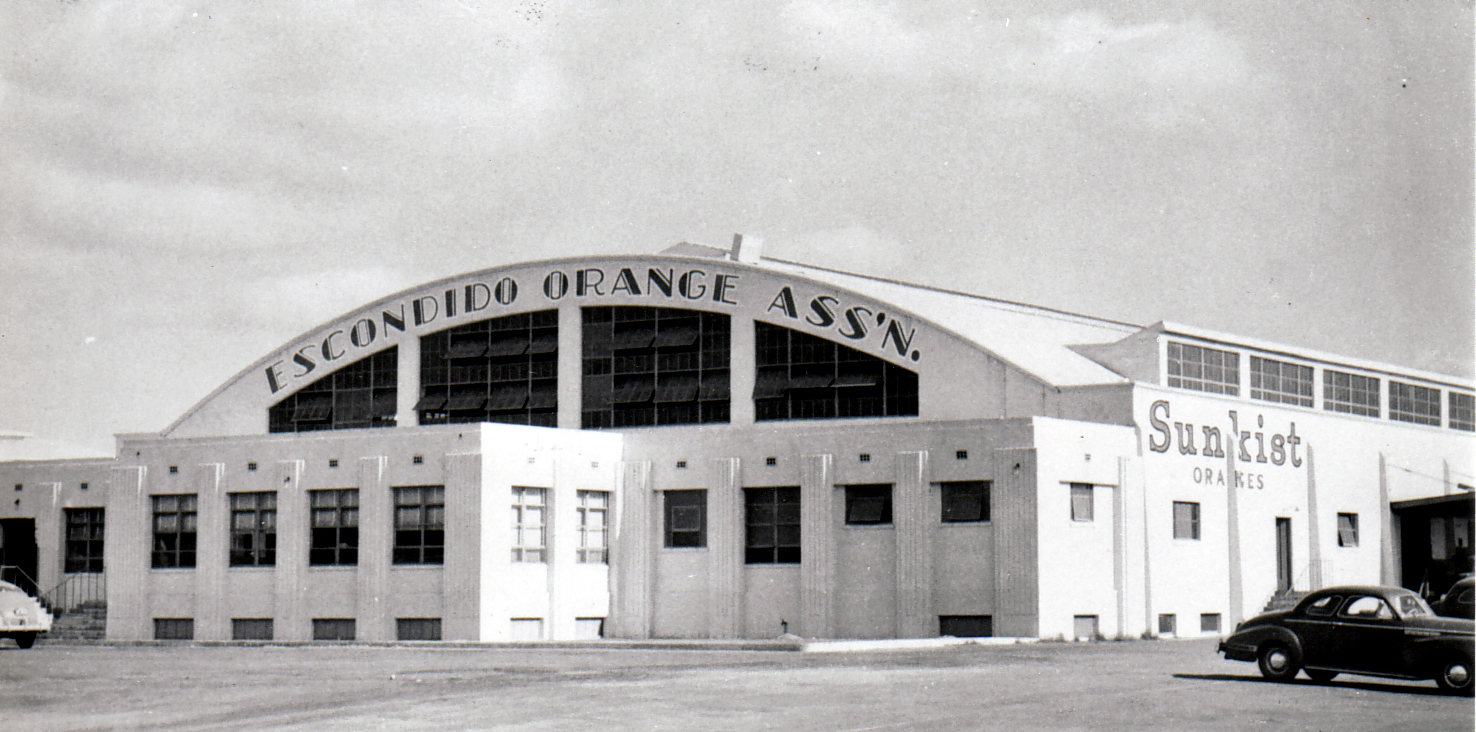 The white Escondido Orange Association packing-house facade with Sunkist signs.