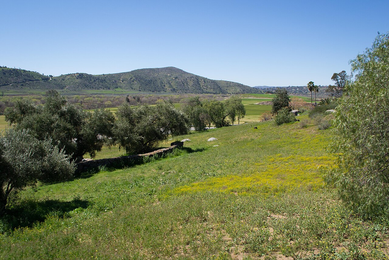 Present-day view across the green floor and low hills of San Pasqual Valley.